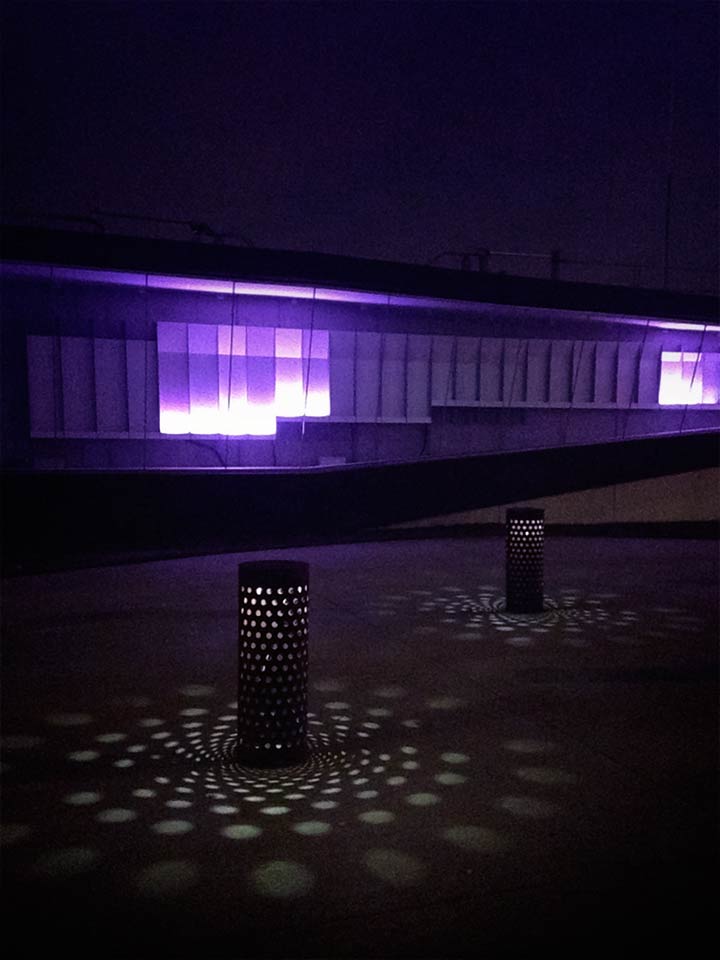 Custom cylinder sidewalk lights cast unique shadows through perforations.