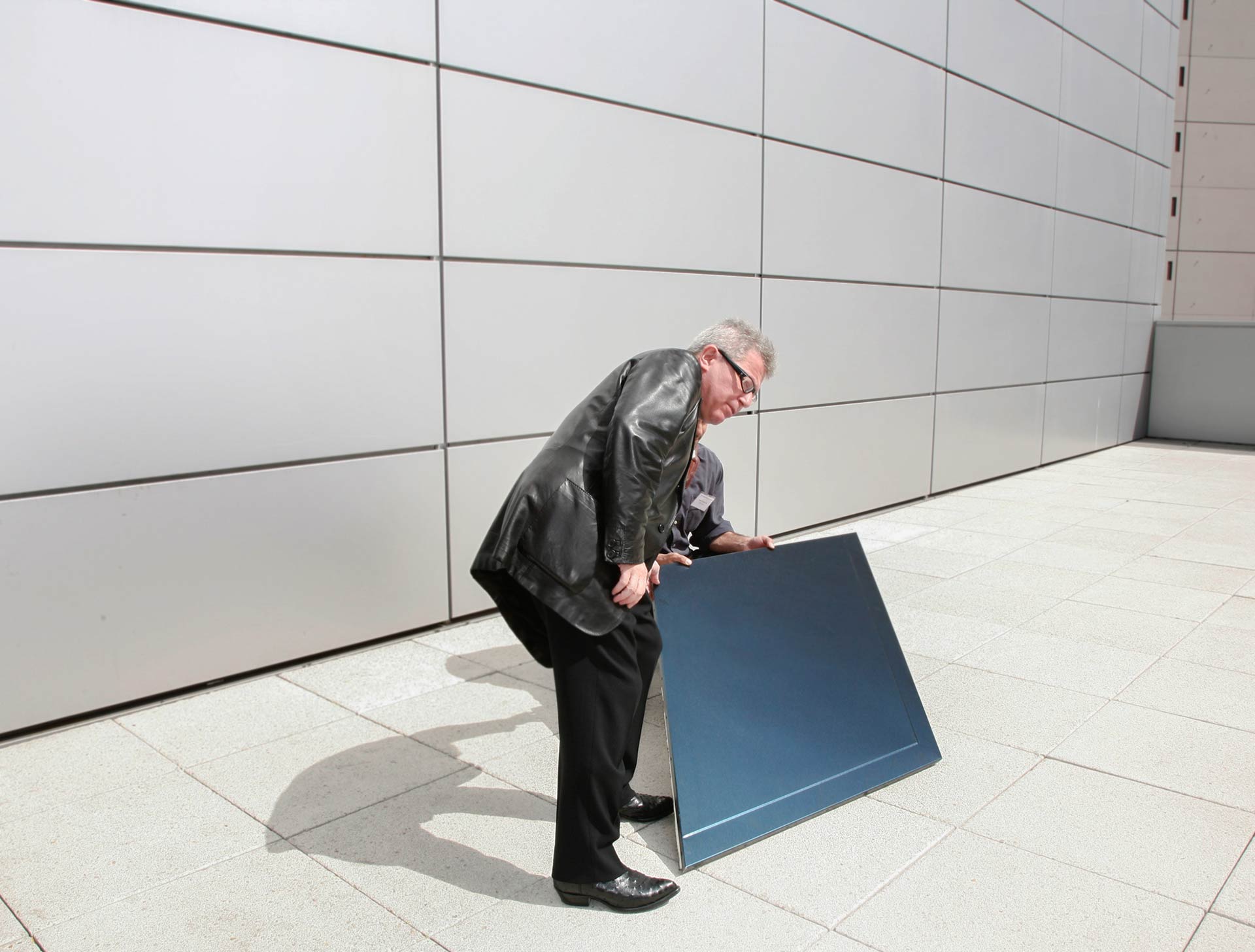 Daniel Libeskind examines the light reflectivity of one of Zahner's panels.