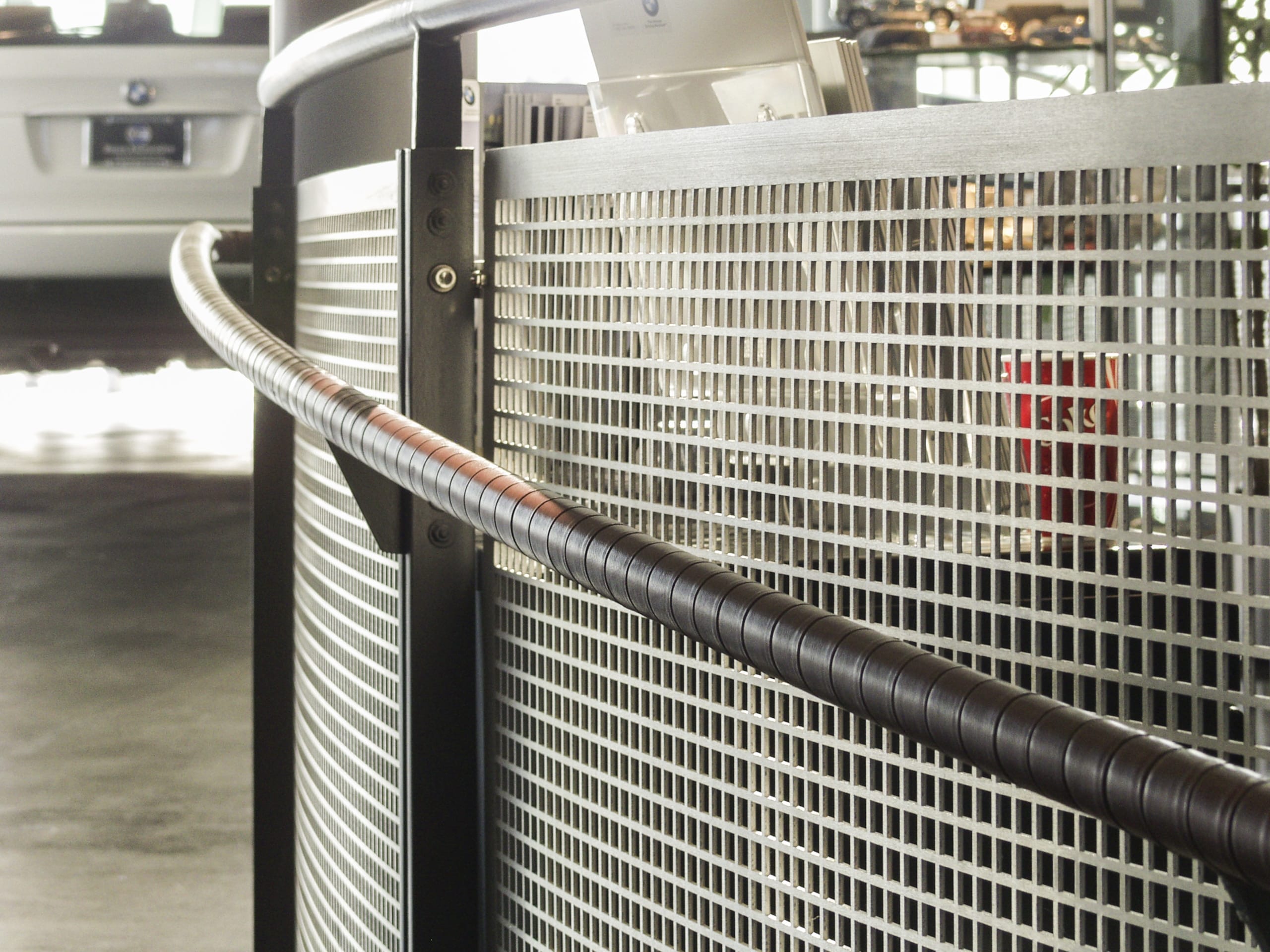 Detail of the satin aluminum and leather handrail for Baron BMW in Merriam, Kansas