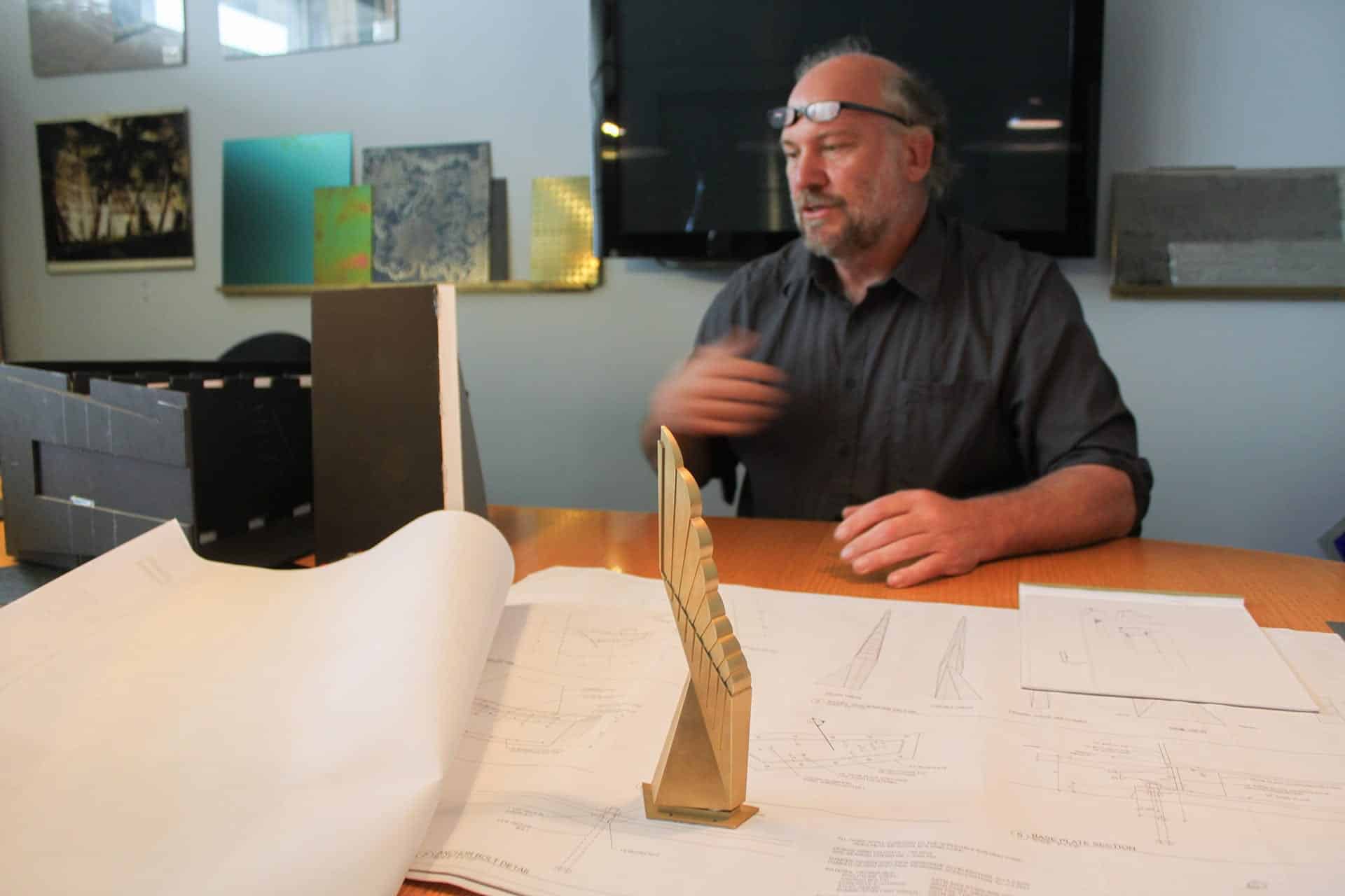 Photograph of John Lajba with his Winged Refuge Sculpture Model.