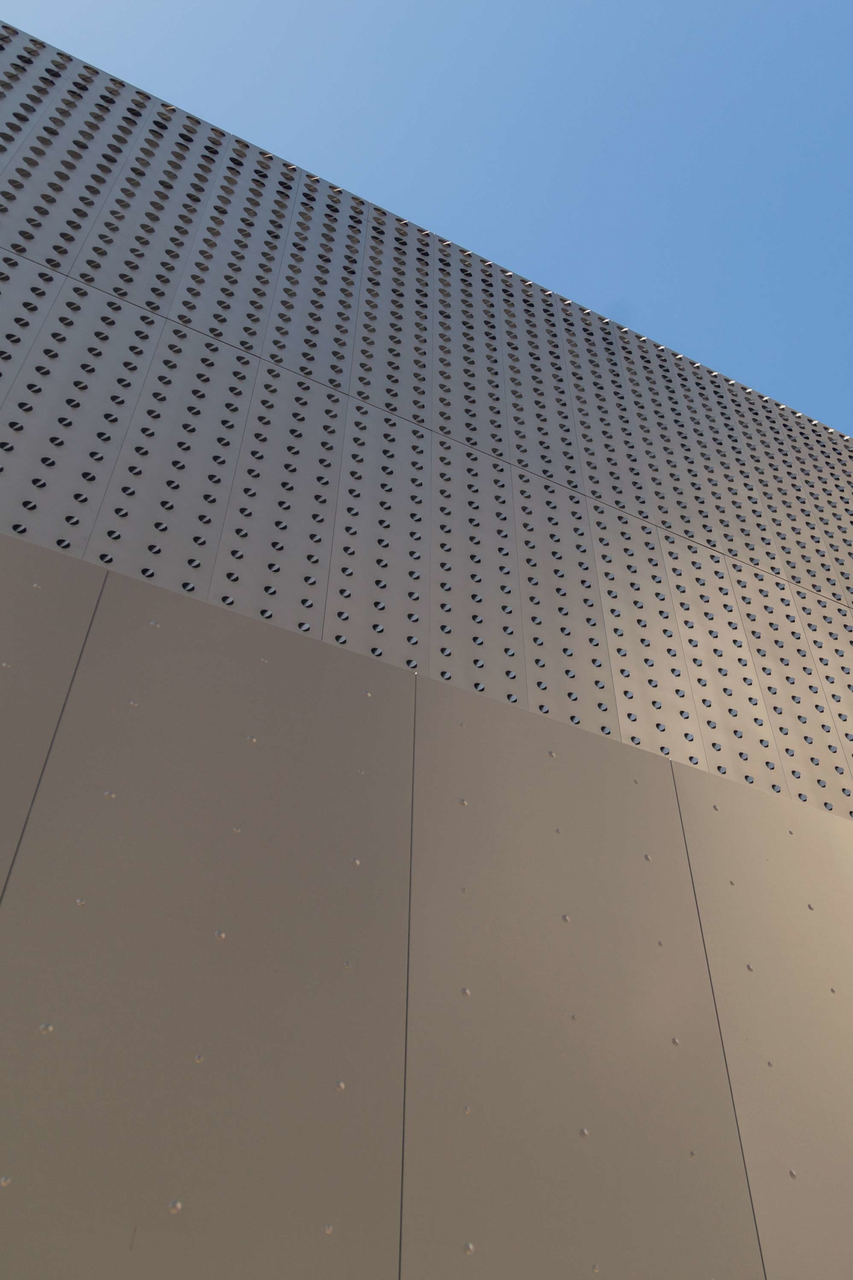 Custom dimpled panels extend the aesthetic established by the louvered perforated panels.