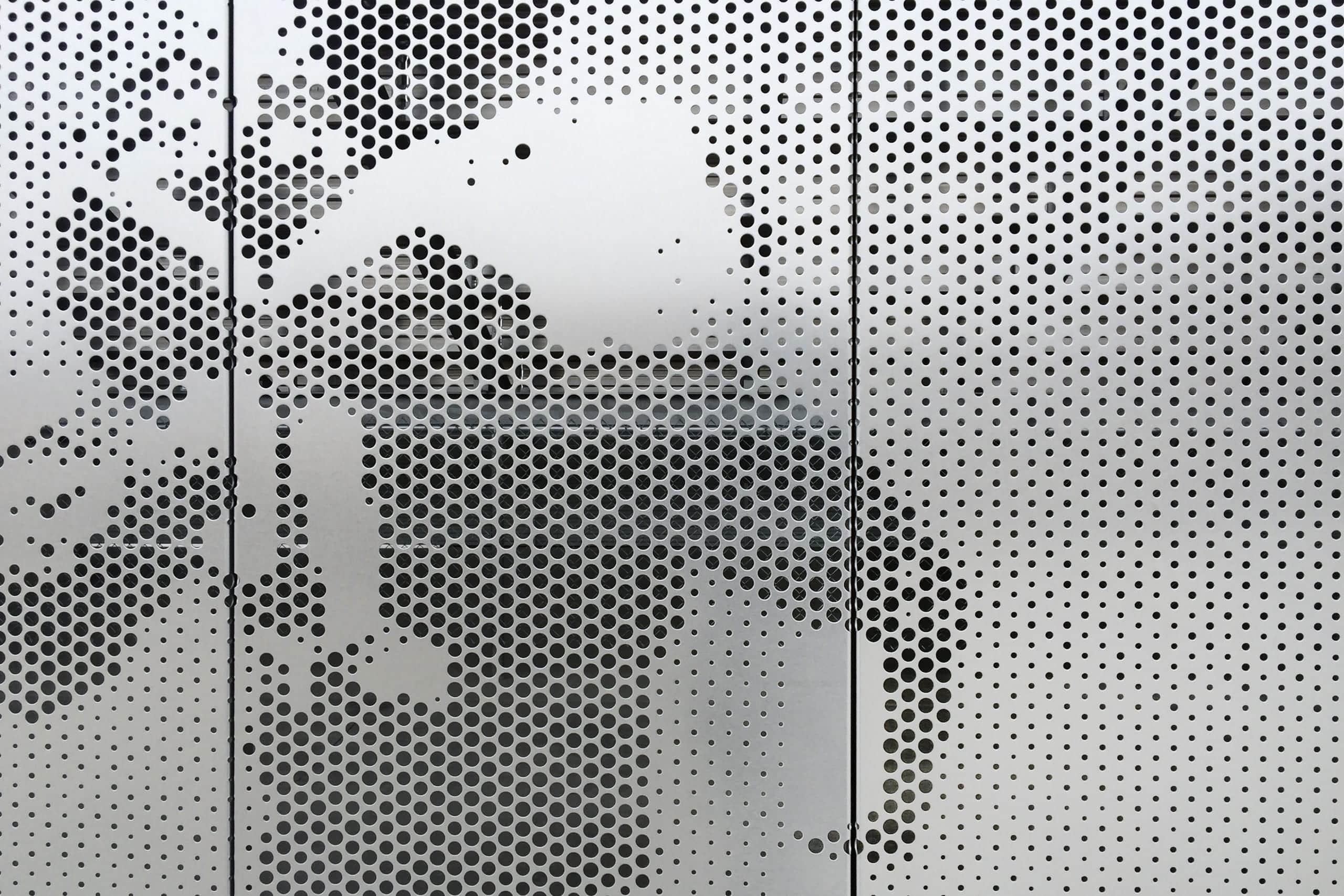 Detail of the Okie Blan<br /></noscript> chard Sports Complex perforated stainless steel.” /></picture>
<p class=