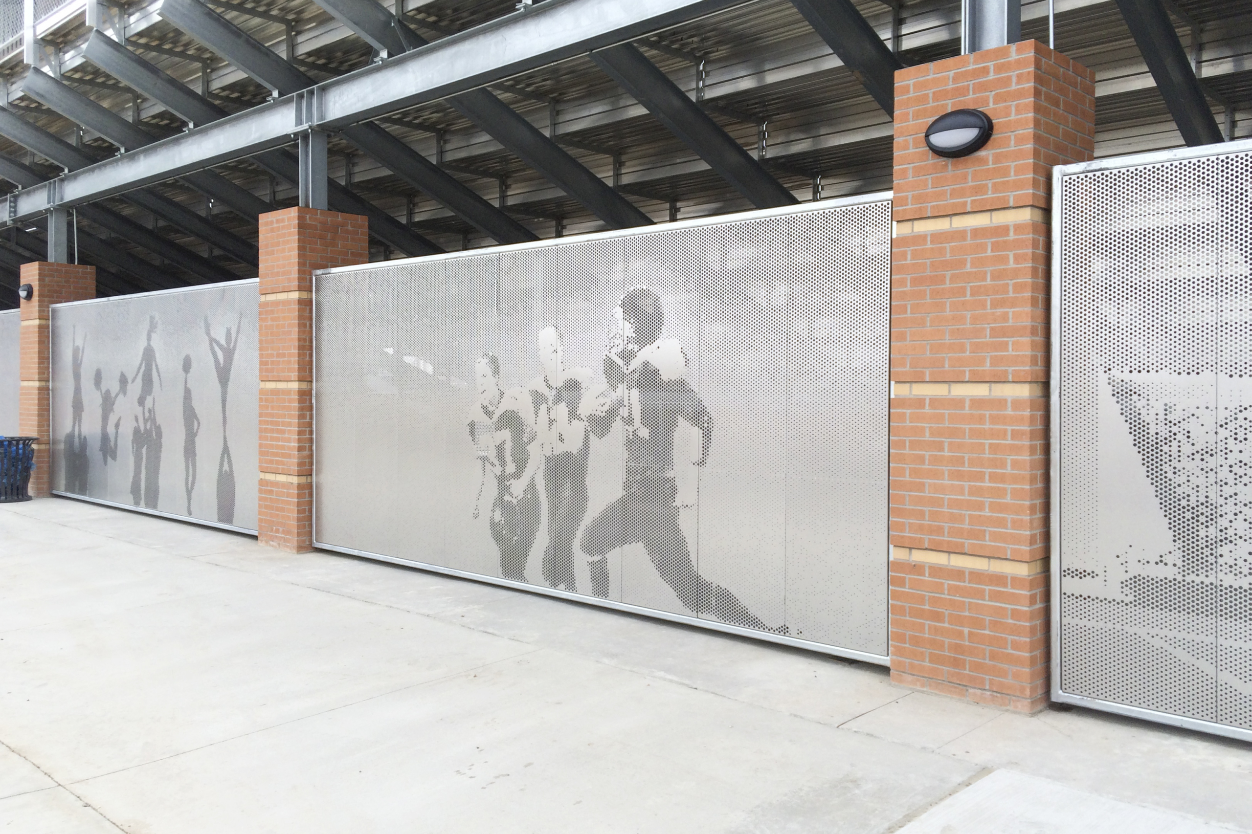 Perforated metal screen wall prevents access to under bleachers without drawing attention to its inherent security.